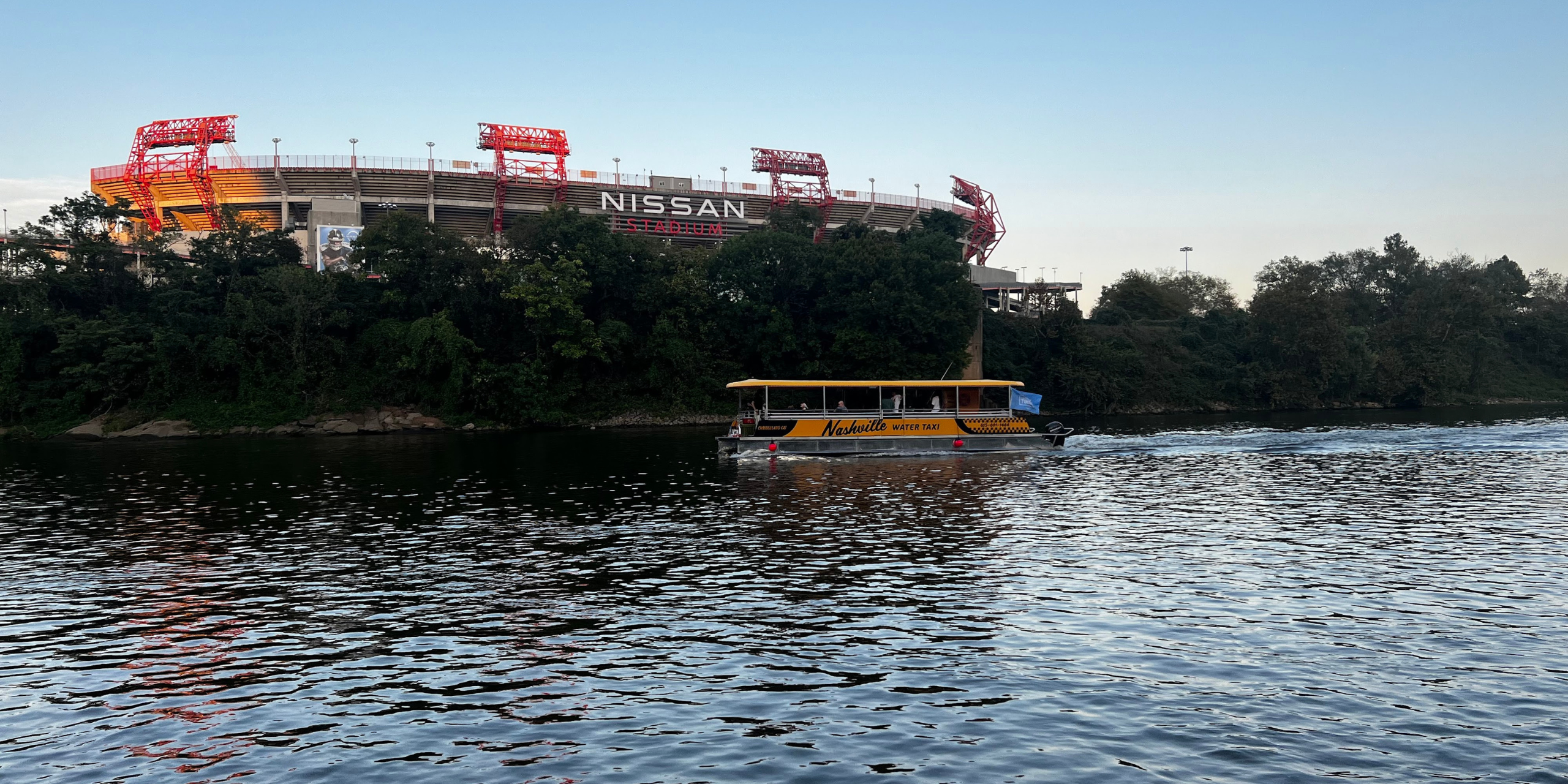Nashville Water Taxi boat cruising in front of Nissan Stadium